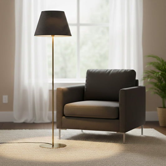 Modern gold metal floor lamp with black fabric shade placed beside armchair in bright living room for ambient lighting Decor.