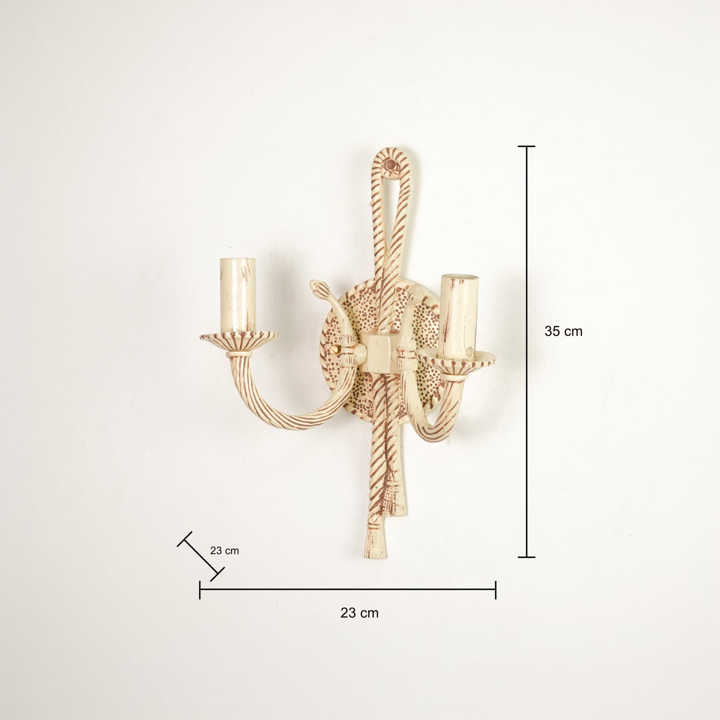 A wall-mounted two-light candle-style sconce in a warm gold finish, shown with dimension lines and labels indicating a height of 35 cm, width of 23 cm, and candle-tip spacing of 23 cm against a plain white background.