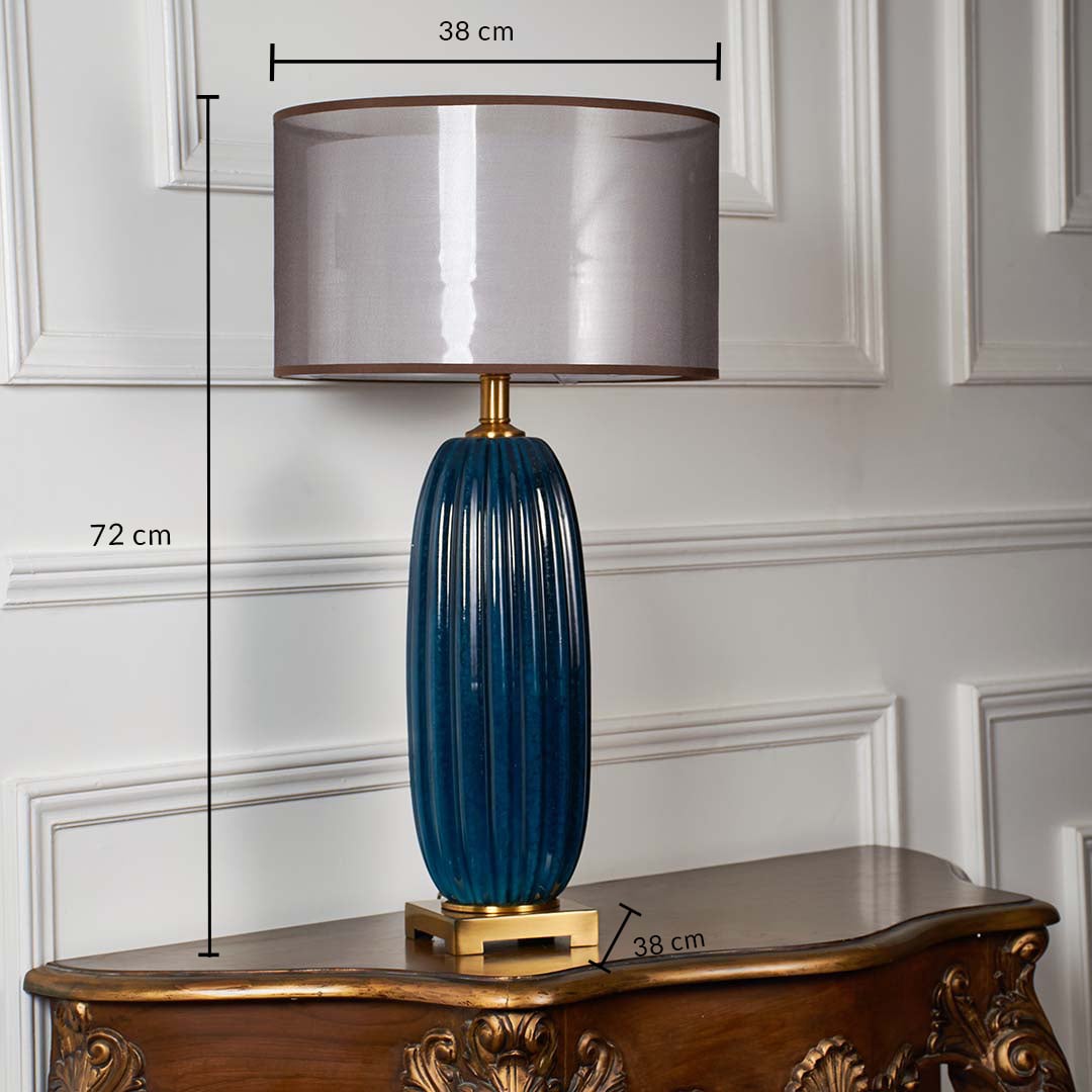 Blue ceramic ribbed table lamp shown with 72 cm height 38 cm shade width and 38 cm base width on a carved wooden console for accurate size reference.