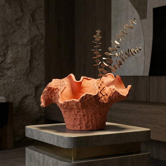 Orange ceramic decorative flower vase placed on table with dried flowers modern artistic home decor styling idea.