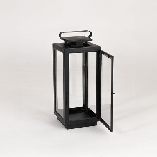 Modern black metal lantern with glass panels on white background suitable for living room balcony and patio Decor.