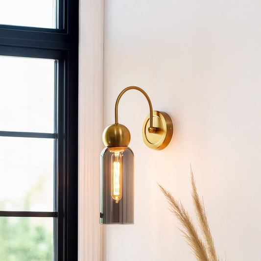 Gold metal wall light with smoked grey glass shade adding warm ambient lighting to a modern home interior.