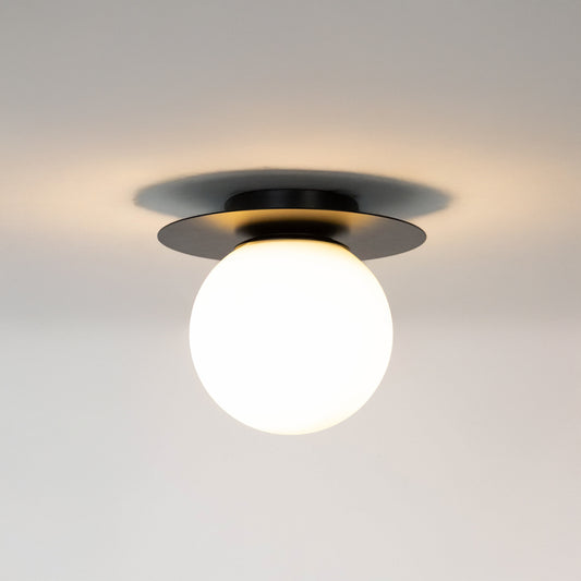 Modern black metal ceiling light with frosted white glass globe for contemporary bedroom and elegant decor styling spaces.