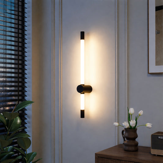 Modern wall light with vertical tube design and black metal mount emitting warm glow ideal for bedroom or living room wall decor.