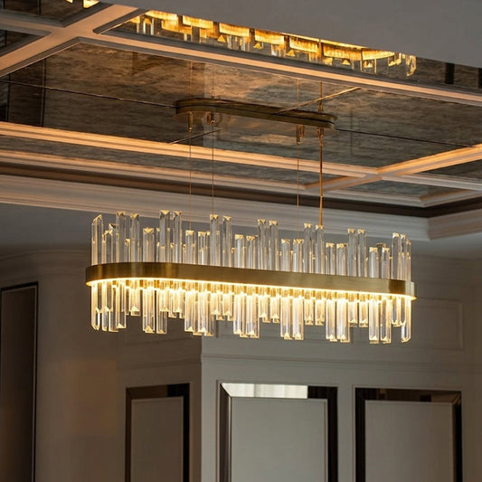 Luxury rectangular crystal chandelier with gold frame casting warm glow above dining area perfect for premium interior lighting setup.