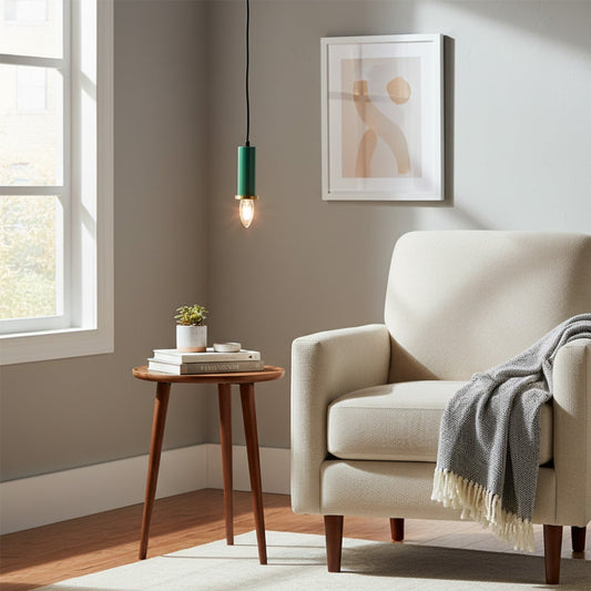 Green metal pendant light hanging near an accent chair creating warm ambient lighting in a modern living room corner space.