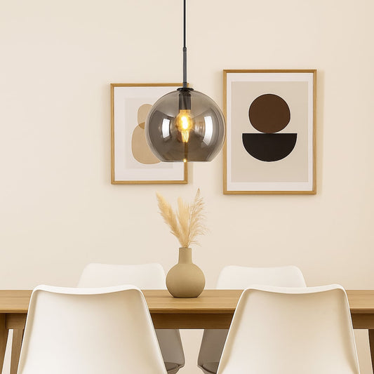 Pendant light with smoked glass shade and metal fitting hanging above dining table creating soft illumination and modern dining room style.