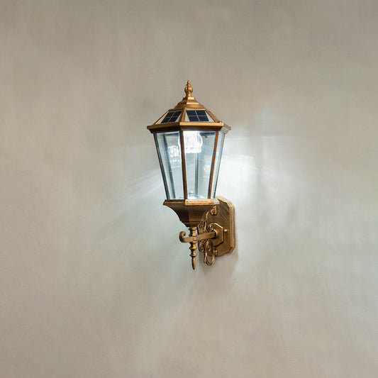 Vintage bronze outdoor wall light on white background with clear glass shade for elegant exterior decor.