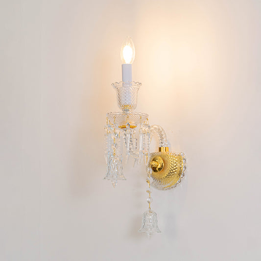 Classic crystal wall light in gold finish with single candle bulb for bedroom or living decor lighting white background.