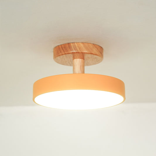 Closeup of peach metal and natural wood ceiling light for contemporary bedroom and Scandinavian decor styling spaces.
