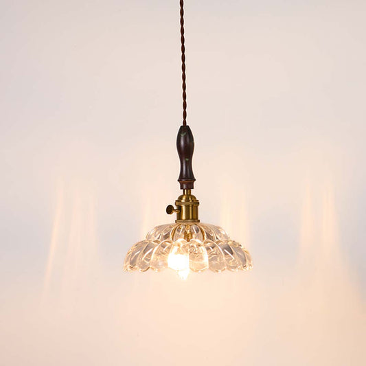 Textured clear glass and brass metal pendant light with warm glow for stylish home interiors.