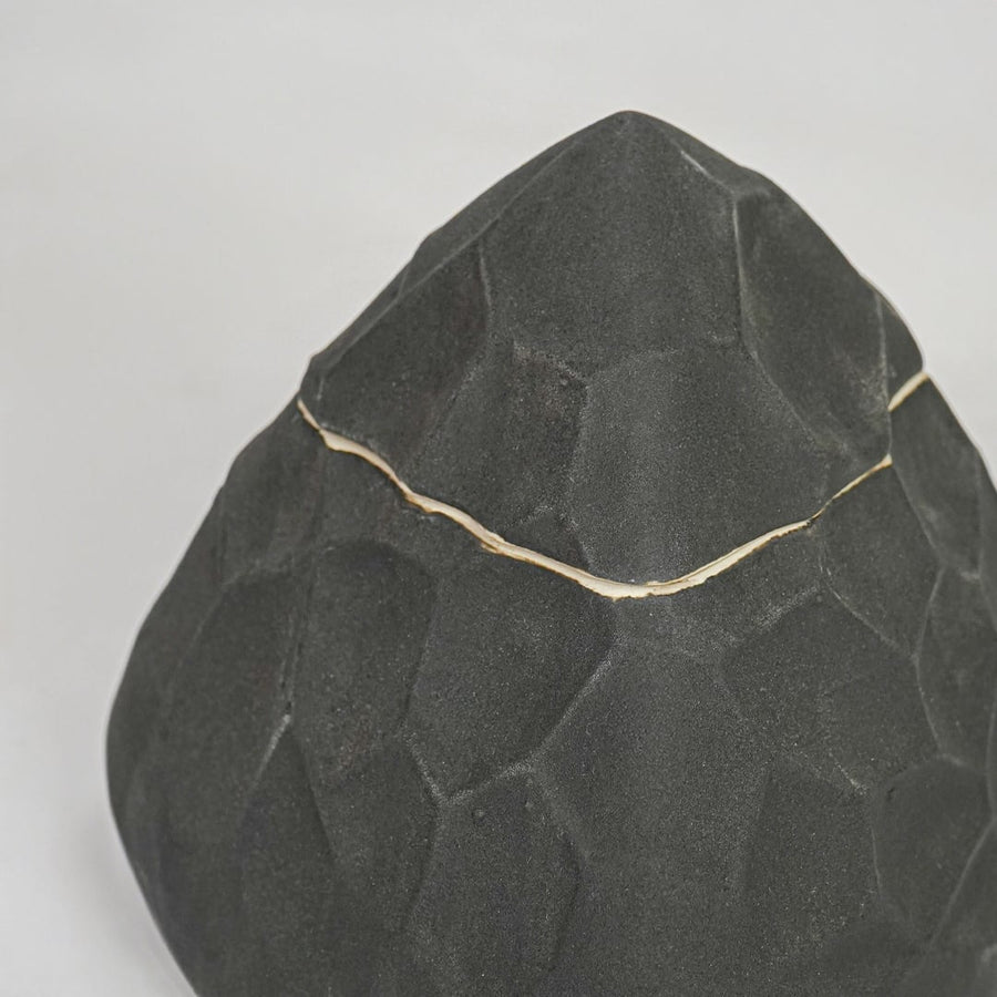 Closeup black textured decorative object surface detail modern ceramic decor piece for table shelf console styling.