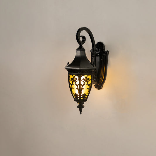 Classic black outdoor wall lantern on white background featuring an intricate vintage filigree metal overlay design.