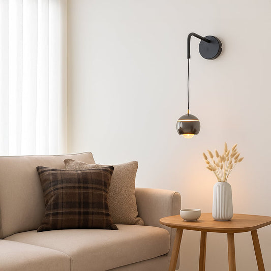 Table lamp style wall light shown in a bright lifestyle view with a modern hanging globe shade adding soft ambient lighting to interior spaces.