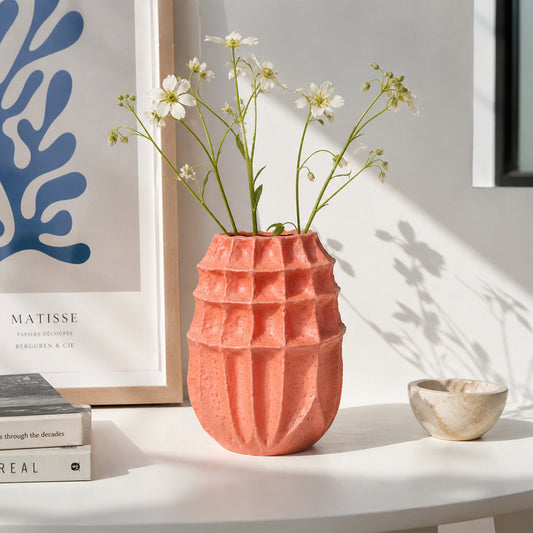 Coral textured ceramic flower vase with fresh blooms placed on table for stylish modern home decor.