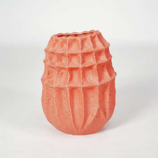 Pink textured ceramic vase for modern shelf placement and artistic indoor living room decor styling accent piece.