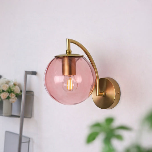 Modern pink glass and gold metal wall light for elegant bedroom and luxury living room decor spaces.