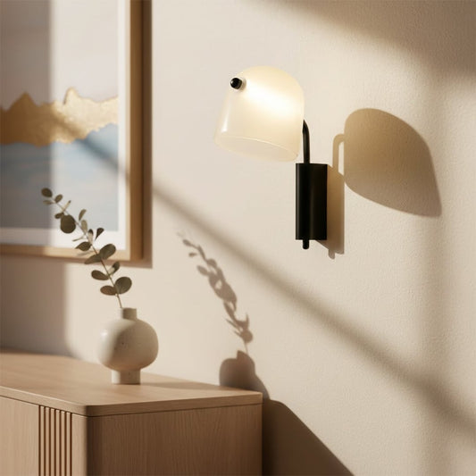 Modern white and black wall light with warm glow for stylish bedroom and contemporary home decor spaces.