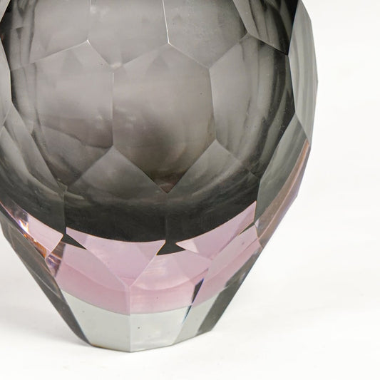 Close view of grey and pink glass decorative vase highlighting faceted geometric texture and glossy reflective finish.