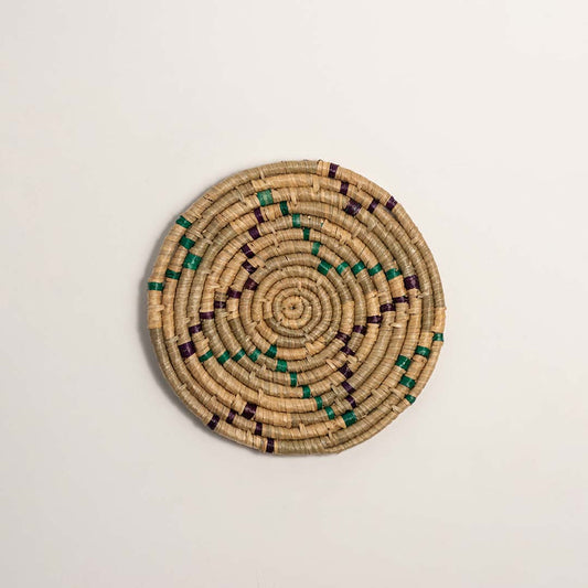 Green and natural woven decorative wall basket with geometric floral pattern for elegant wall styling and home decor.