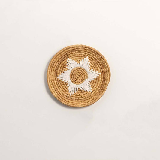 Natural woven seagrass wall basket with sunburst pattern for living room décor on white background image.
