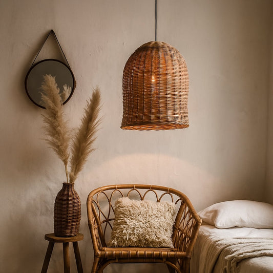 Modern brown rattan hanging lamp illuminating a cozy bedroom with a rattan chair pampas grass round mirror and white bedding in soft light.
