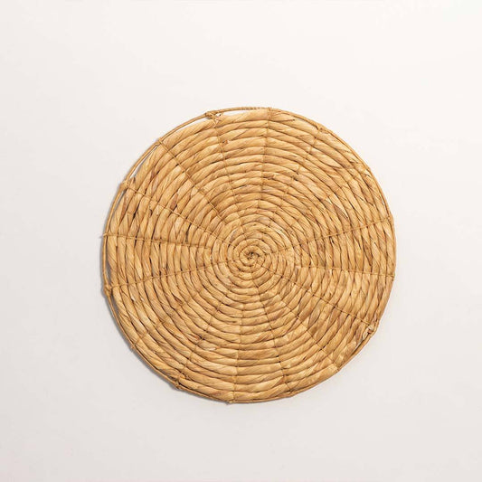 Round handcrafted solid natural wicker seagrass wall basket with woven spiral design on white background product image.