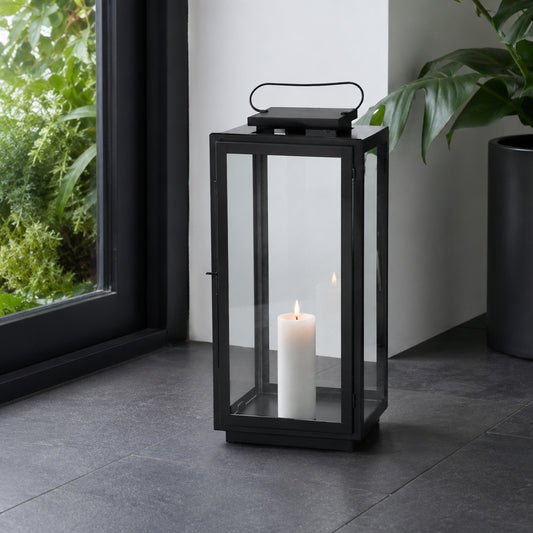Lifestyle image of large metal tower lantern for rustic patio decor styling and modern outdoor home garden lighting design.