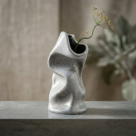 Lifestyle grey ceramic modern art flower vase placed on stone table with dried stem aesthetic home decor styling idea.