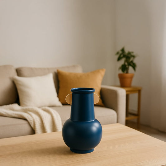 A modern blue vase with rounded base styled in a clean minimal setting adding a bold artistic touch to contemporary home decor.