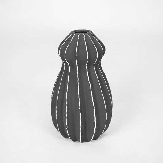 Black textured ceramic vase with striped design for modern shelf placement and elegant indoor decor styling accent.