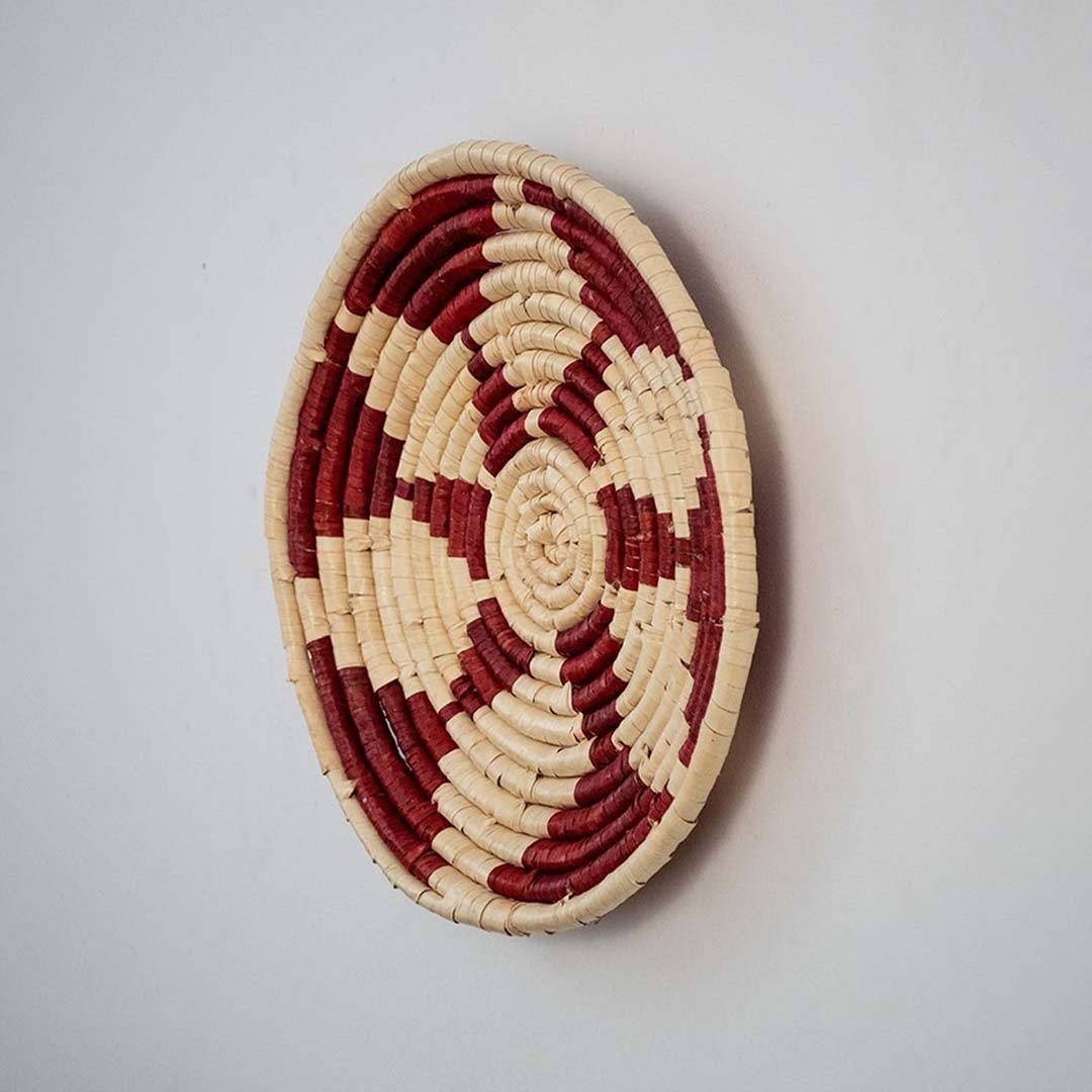 Handwoven woven wall basket decor in natural beige and burgundy with raised woven profile shown on white background.