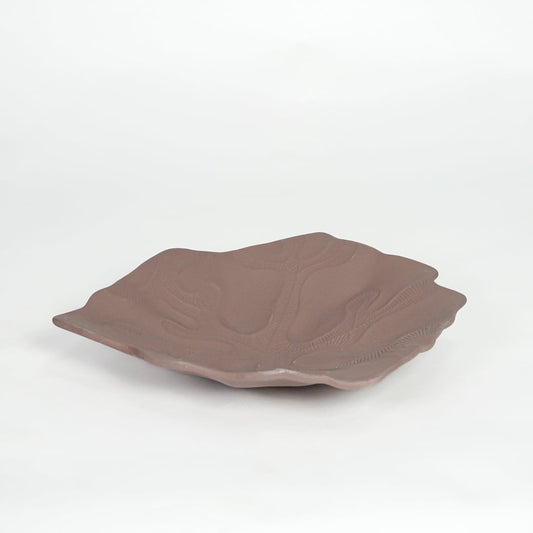 Rustic brown ceramic display platter with sculpted surface and wide design isolated on white background.
