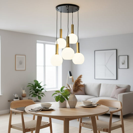 Modern pendant cluster with five white globe shades and gold holders hanging from a black ceiling plate creating a bright elegant room ambience.