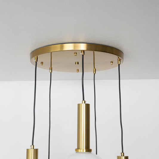 Close view of white globe pendant lights with sleek gold metal holders highlighting their smooth modern finish for stylish interior lighting.