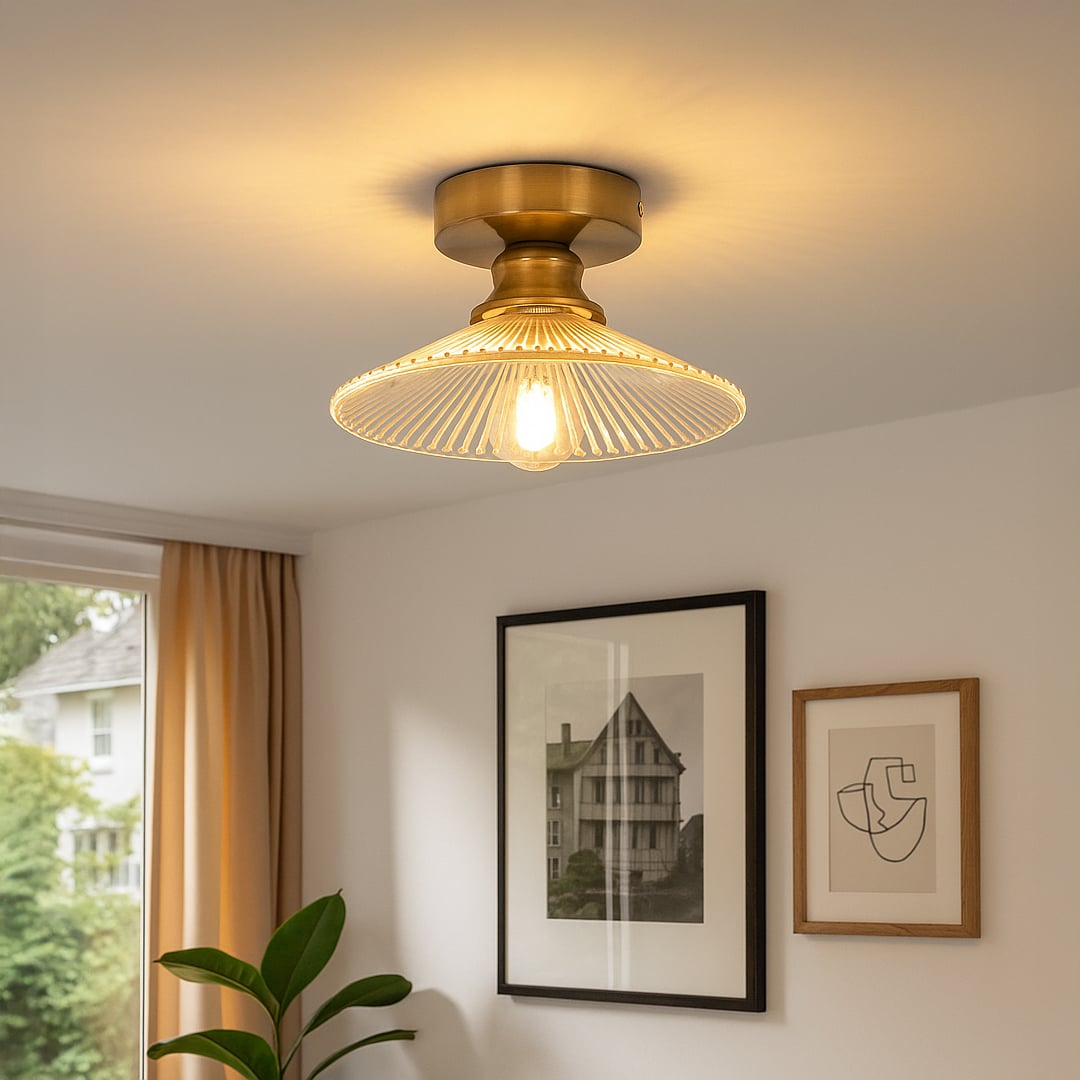 Modern ceiling light with brushed gold base and clear glass shade styled in living room for warm home interior lighting.