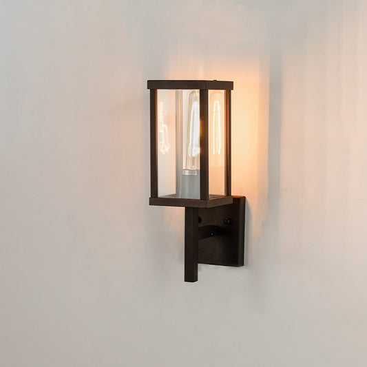 Modern black rectangular outdoor wall light on white background with clear glass panels casting a vertical backplate glow.