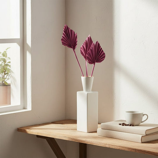 Slim white vase with pink floral stems placed by window creating soft natural light mood and elegant home Decor styling.