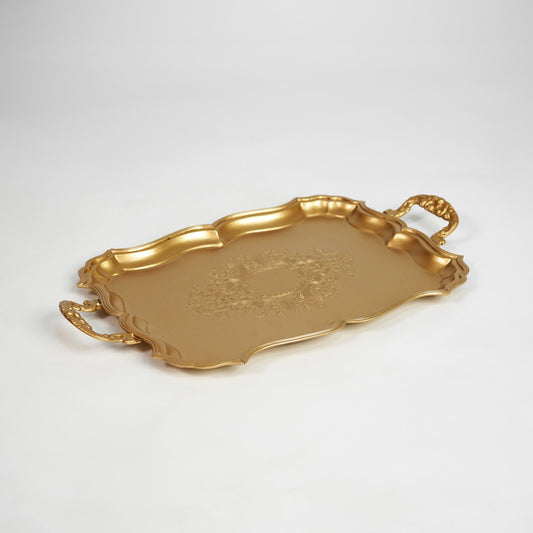 Gold metal serving tray with decorative handles for dining table coffee table on white background image.