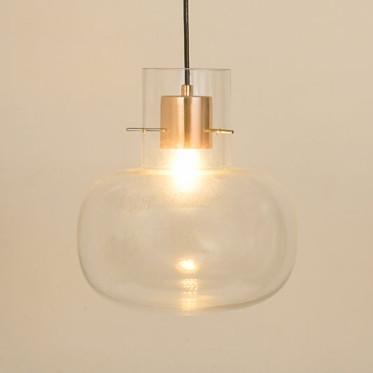 Modern clear glass pendant light with rose gold metal fitting for dining room kitchen island and warm ambient lighting.