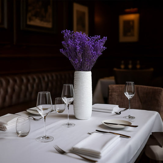 Purple dried gypsophila bunch held by hand in a bright room adding vibrant natural decor to modern home interiors.