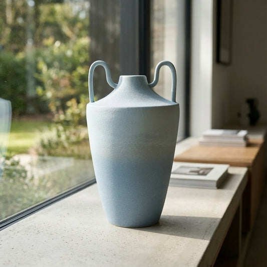 Light blue ceramic decorative flower vase placed near window modern aesthetic home decor styling idea.