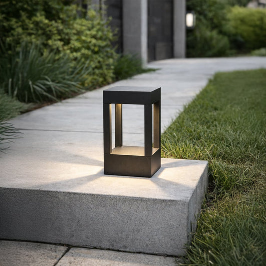Black metal outdoor lantern light placed on concrete step for elegant exterior lighting decor styling ideas.