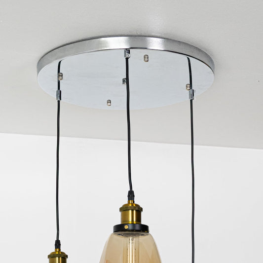 Close view of amber and smoked glass pendant shades showing their smooth tinted finish and gold detailing for stylish modern interior lighting.