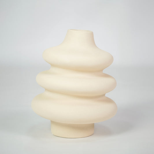 Cream textured ceramic vase for modern shelf placement and elegant indoor home decor styling accent piece.