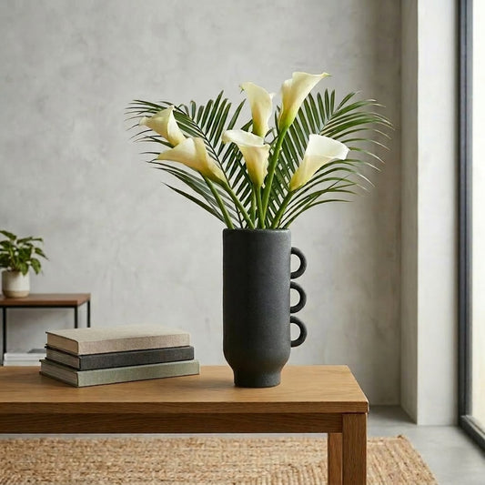 Lifestyle black ceramic decorative flower vase placed on wooden table with flowers modern living room home decor styling idea.