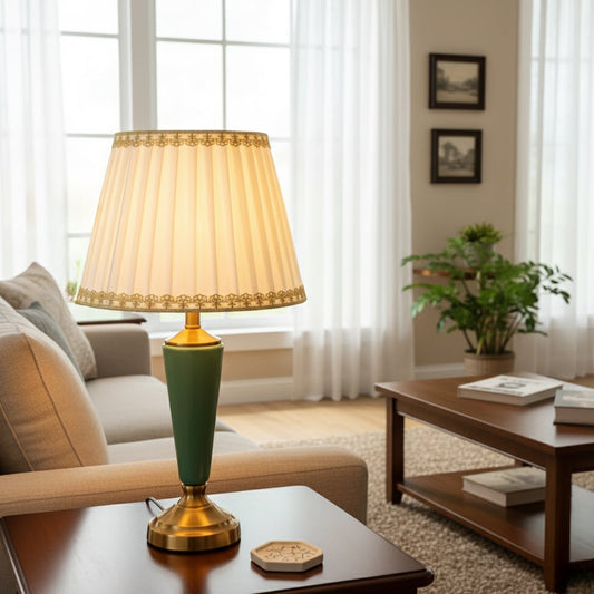 Table lamp with green metal base and pleated white shade styled on a wooden console for elegant warm home decor.