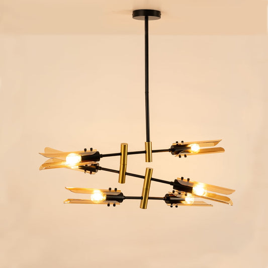 Black and gold chandelier with amber glass lights glowing softly on white background showcasing refined craftsmanship and design.