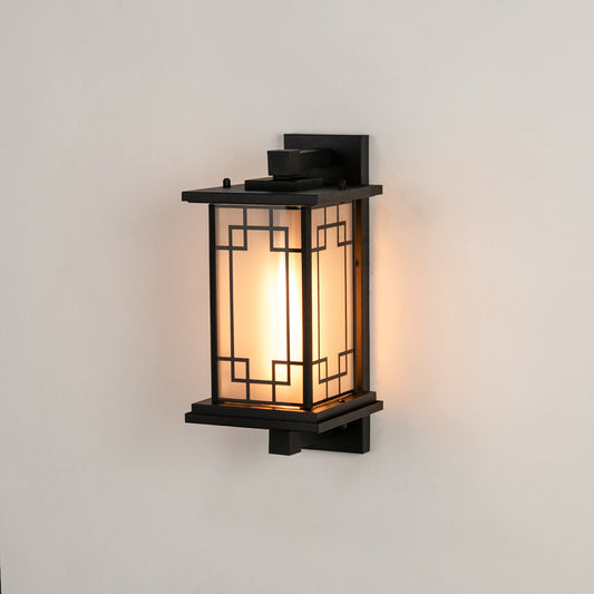 Black metal outdoor wall light on white background featuring a frosted glass shade and geometric frame overlay for decor.
