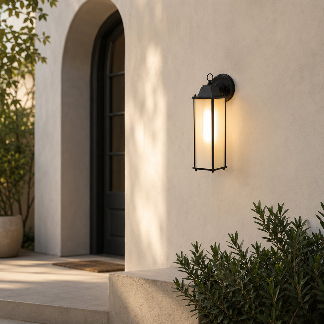 Minimalist black elongated outdoor wall light lifestyle image with frosted glass panels on stucco entryway wall.